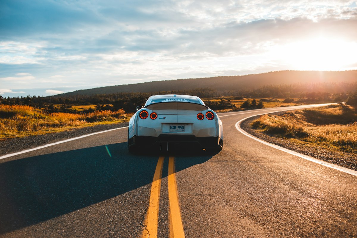 Car on a winding road at sunset