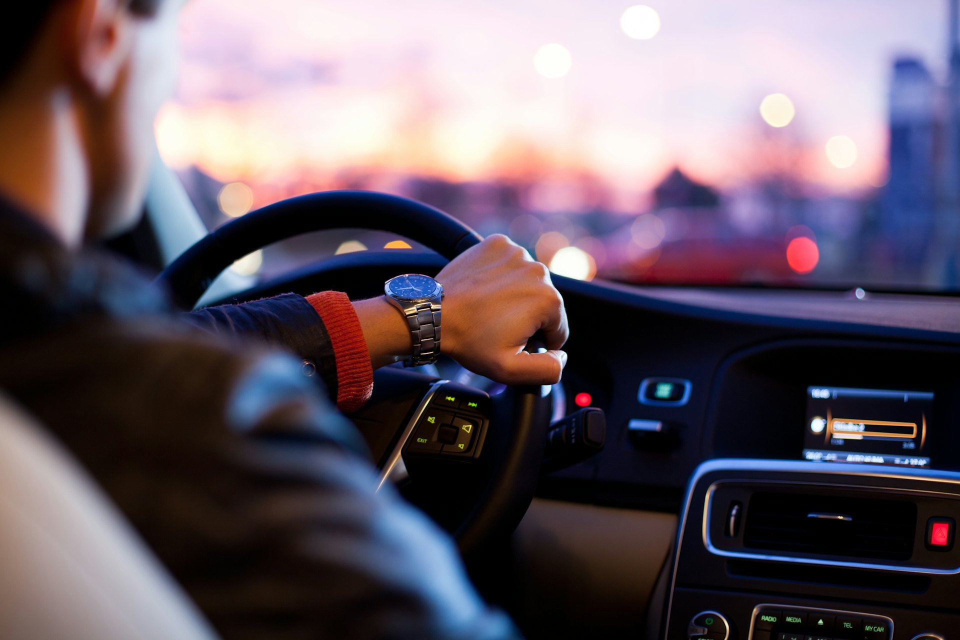 Driver at the steering wheel on a city road at night